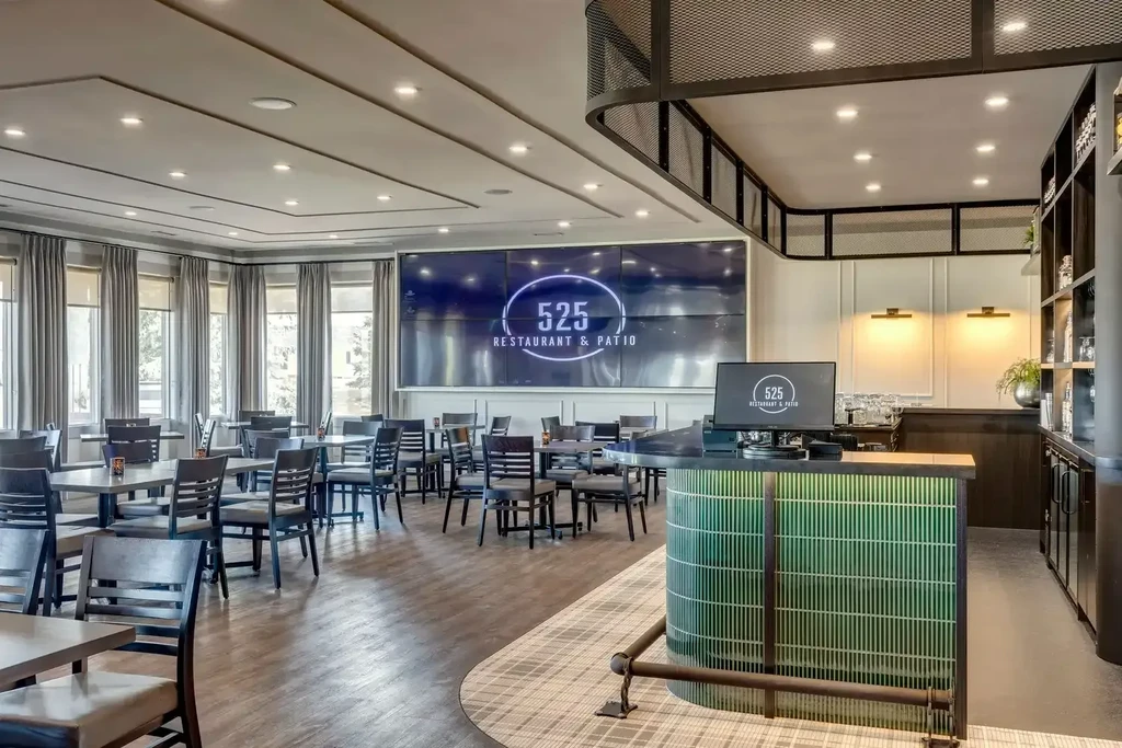 Spacious modern restaurant interior with green-tiled bar and '525 Restaurant' logo.