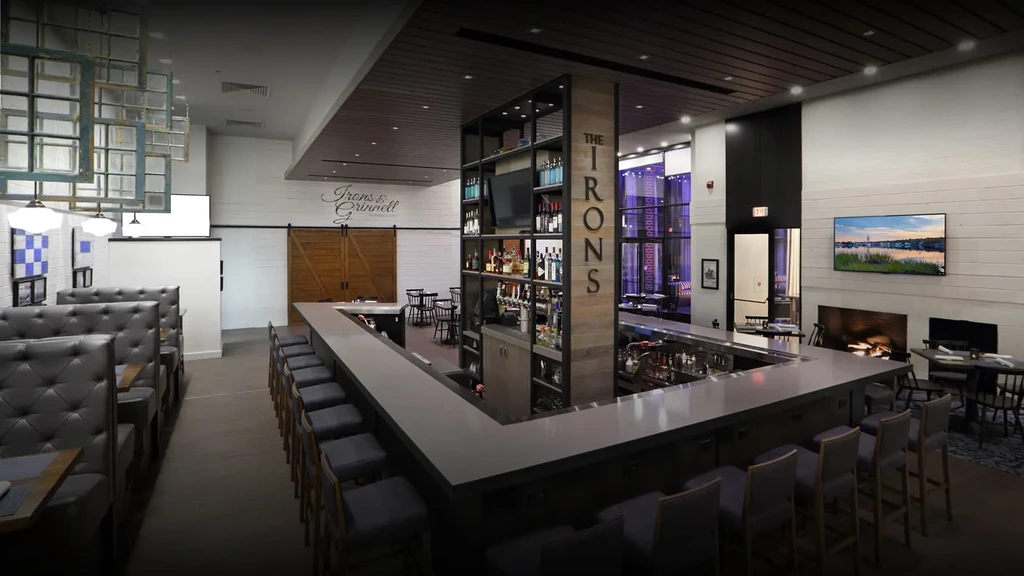 Modern restaurant and bar interior with U-shaped bar, booths, and fireplace.