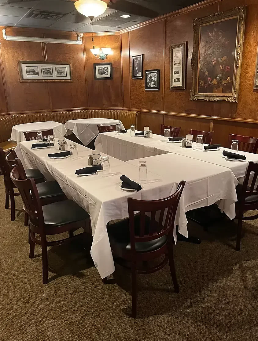 Traditional dining room, U-shaped table, warm wood paneling, no people.