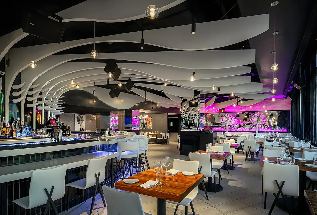 Dining room with sculpted white ceiling, bar seating and wall art