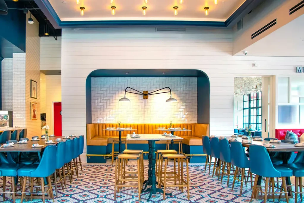 Modern restaurant interior with yellow U-shaped booth and patterned floor.