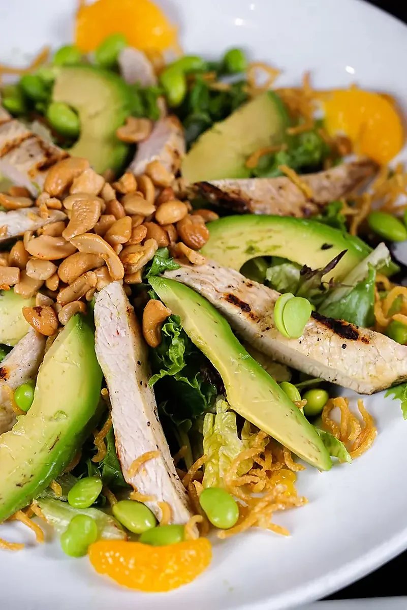 Chicken salad with avocado, edamame, peanuts and mandarin orange segments