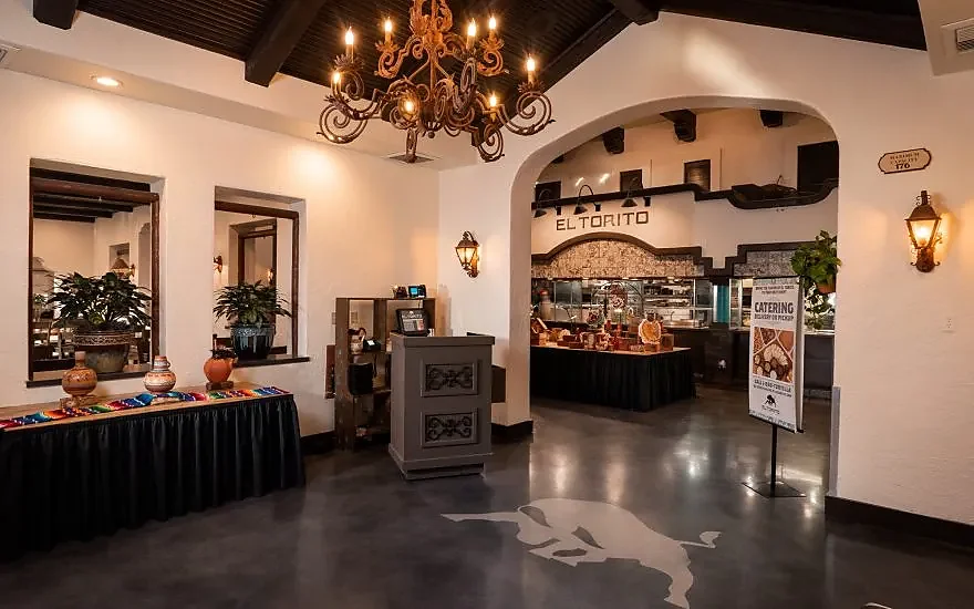 Restaurant entryway with chandelier, arched doorway and tiled interior decor