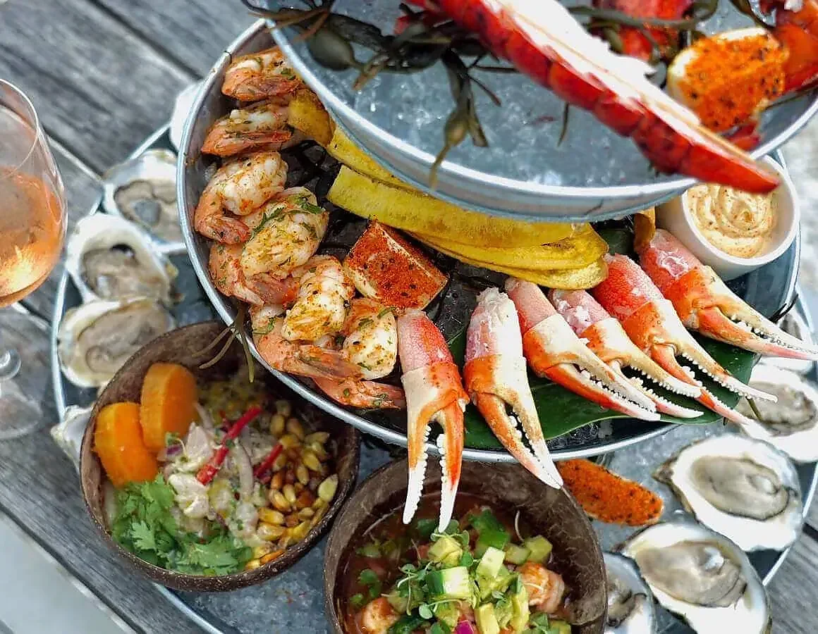 Tiered seafood tower with shrimp, oysters, crab claws and ceviche