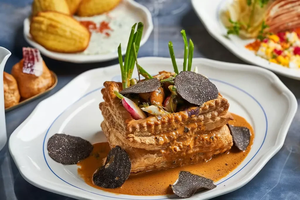 Savory puff pastry vol-au-vent with truffle slices and creamy sauce.