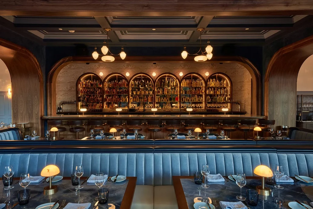 Elegant restaurant interior with a long bar and blue dining booths.