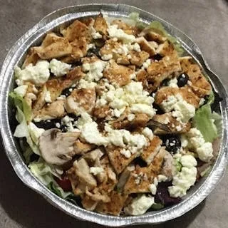 A large aluminum bowl of salad with chicken, feta, and olives.