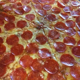 Close-up of a greasy pepperoni pizza with some slices missing.