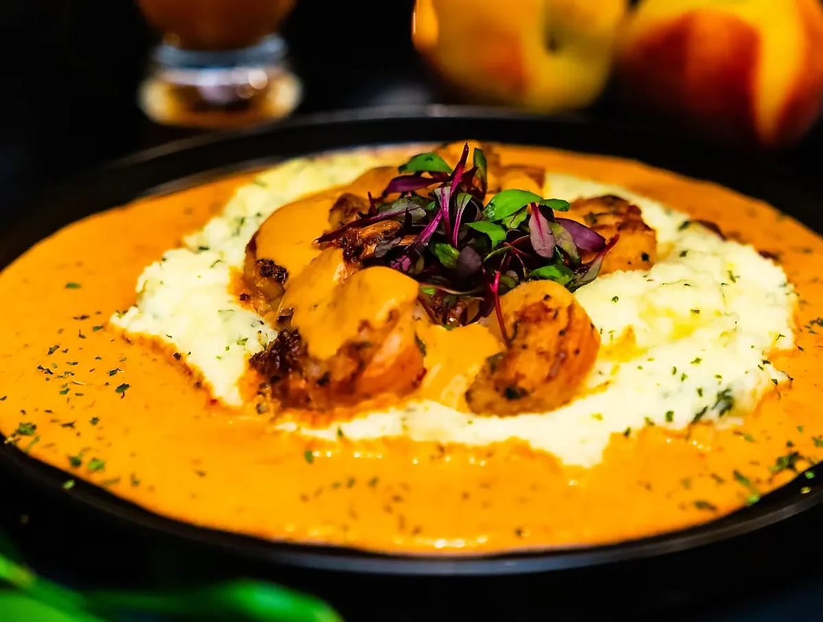 Shrimp and grits in cajun cream sauce in black bowl