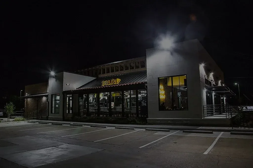 Exterior of Zoli's restaurant building with lit signage at night