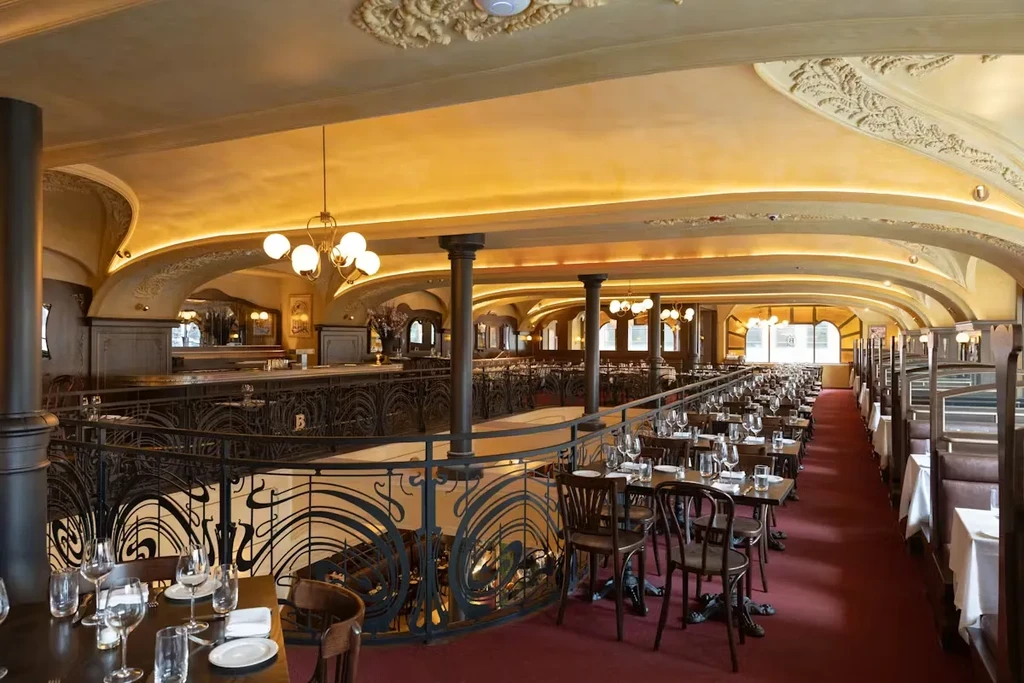 Sophisticated multi-level restaurant interior with Art Nouveau design.