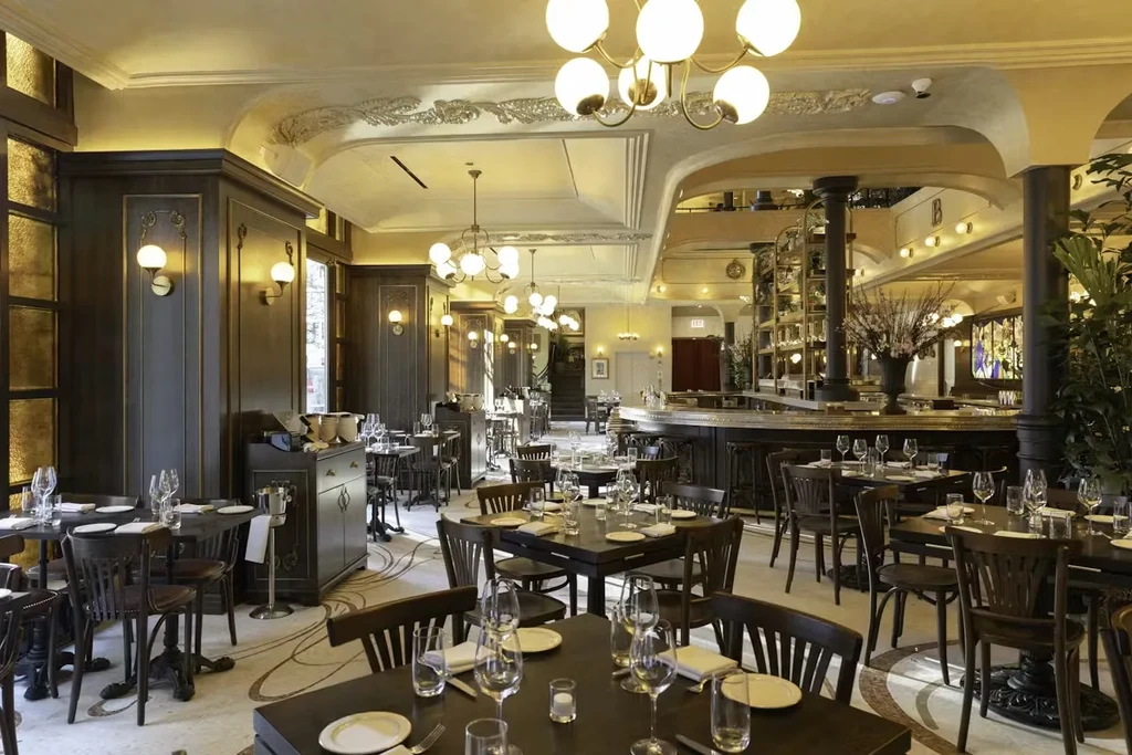 Empty high-end restaurant with dark wood paneling and warm lighting.