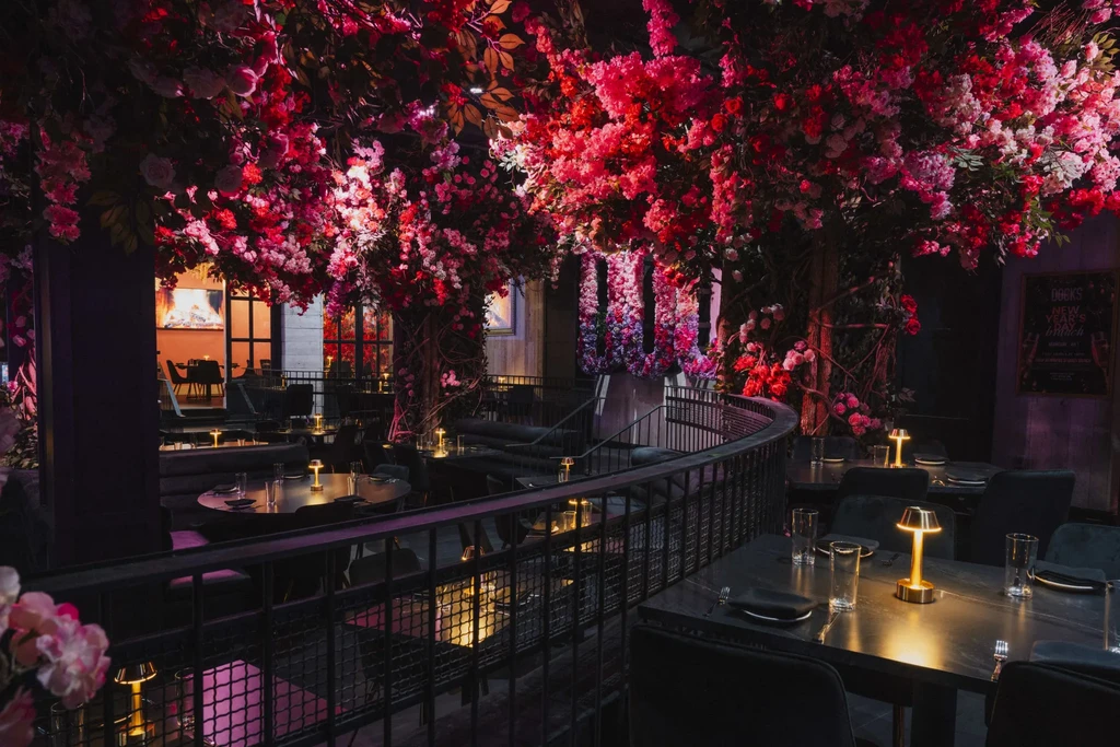 Elegant restaurant with red and pink flowering vines covering the ceiling.