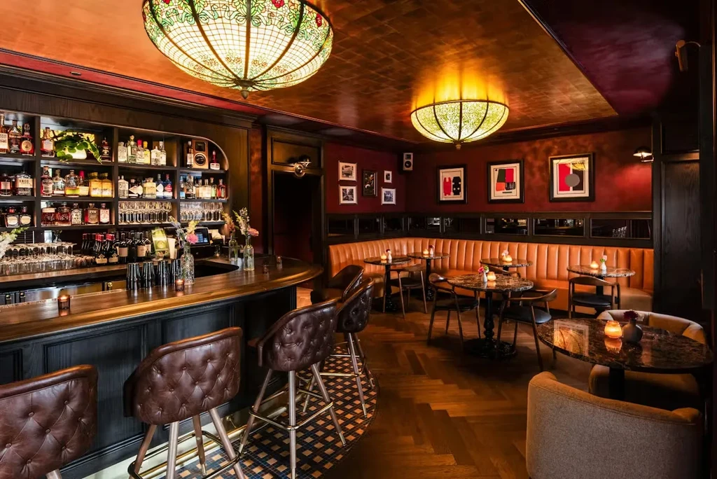 Elegant bar and lounge area with dark wood and warm lighting.