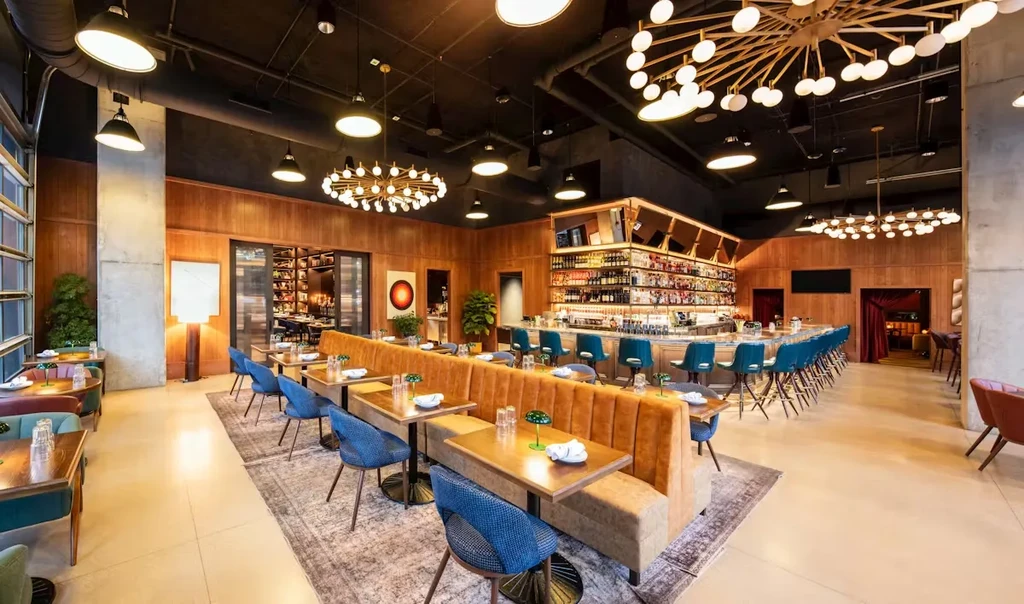 Modern, upscale restaurant interior with a long bar and dining area.