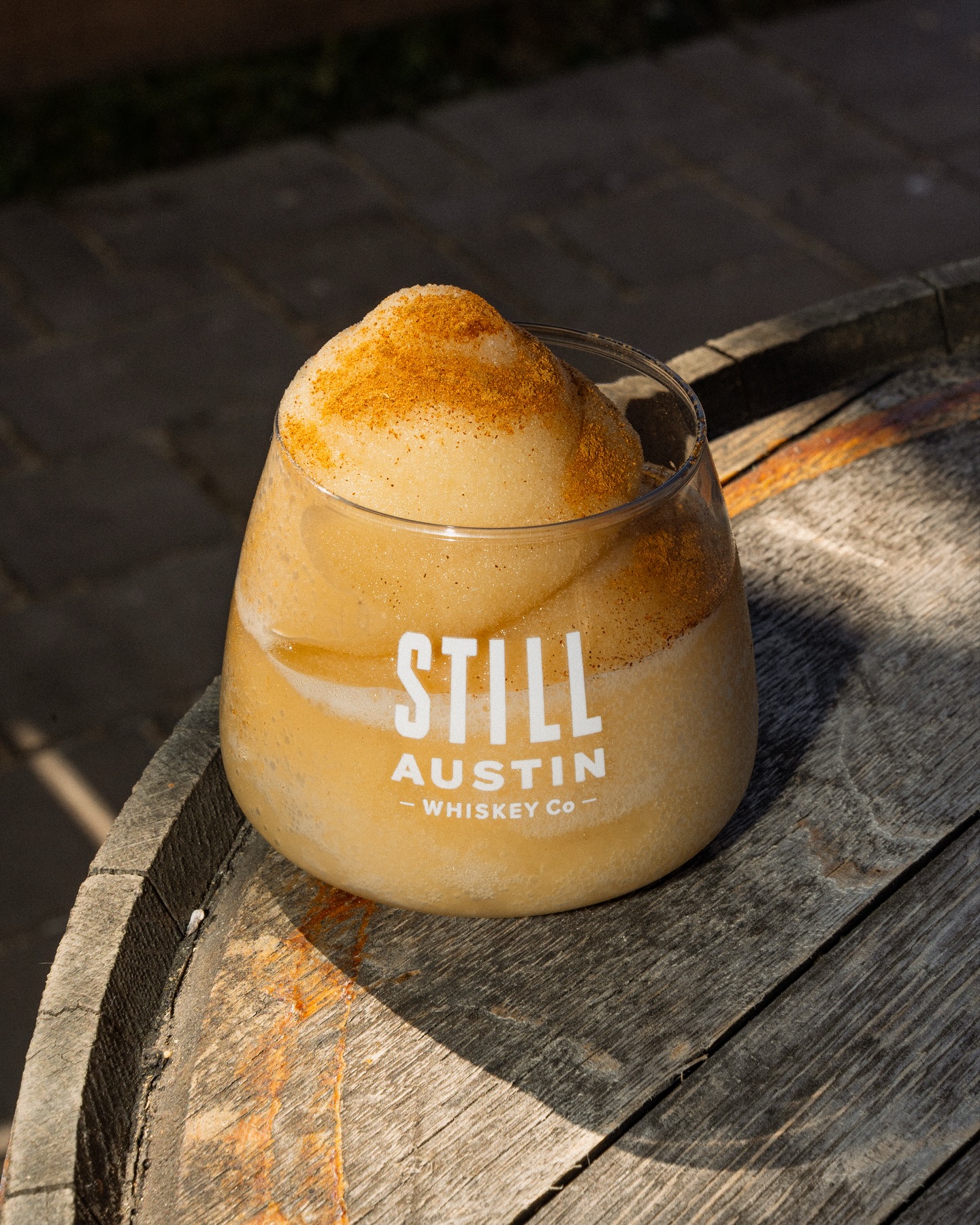 Still Austin frozen drink topped with spice on a wooden barrel.