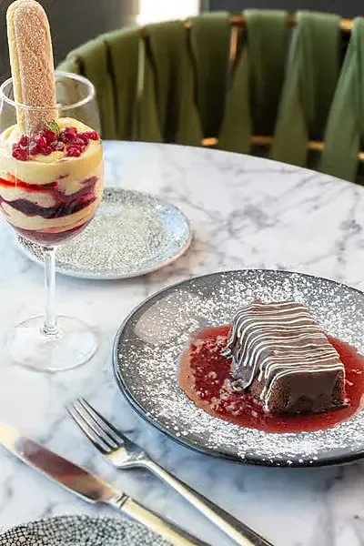 Tiramisu parfait and chocolate dessert with berry sauce on marble