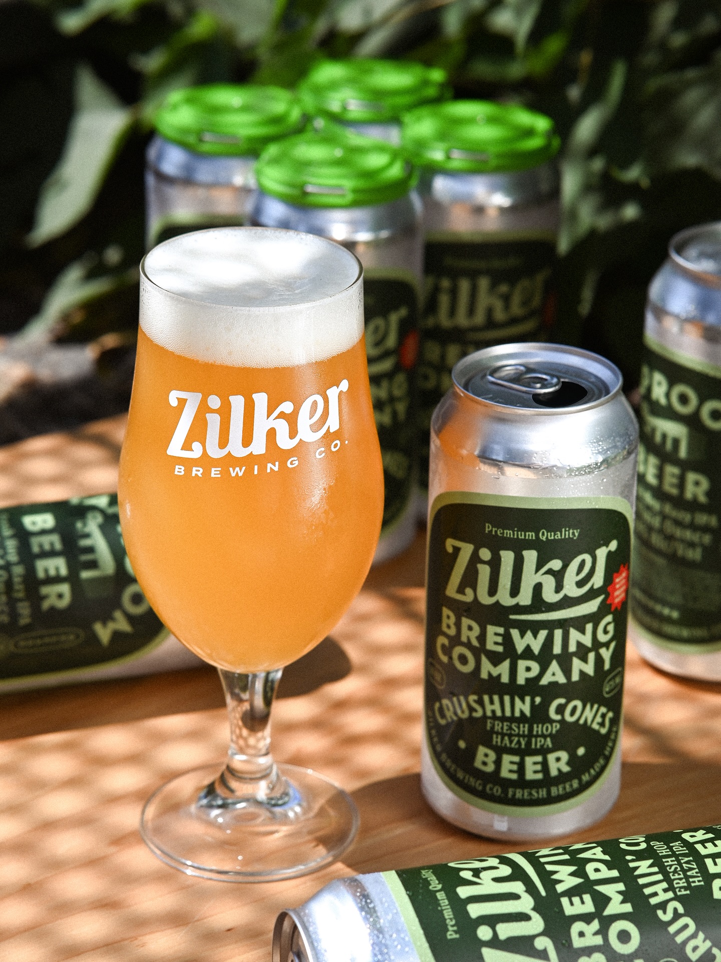 Zilker Brewing hazy IPA beer in a glass and several cans.