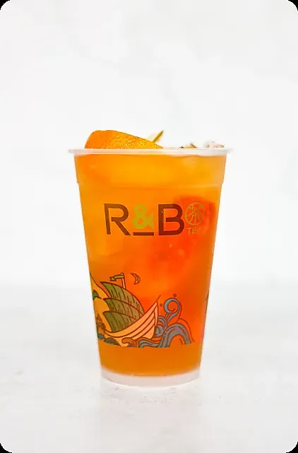 Iced orange fruit tea in branded cup with orange garnish