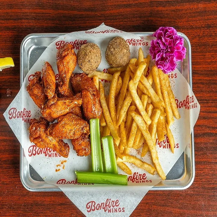 Sauced bone-in wings with seasoned fries, boudin balls and celery