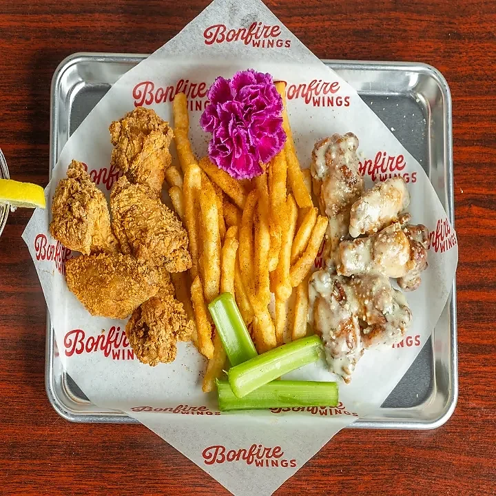 Breaded tenders, seasoned fries and garlic parmesan wings on tray