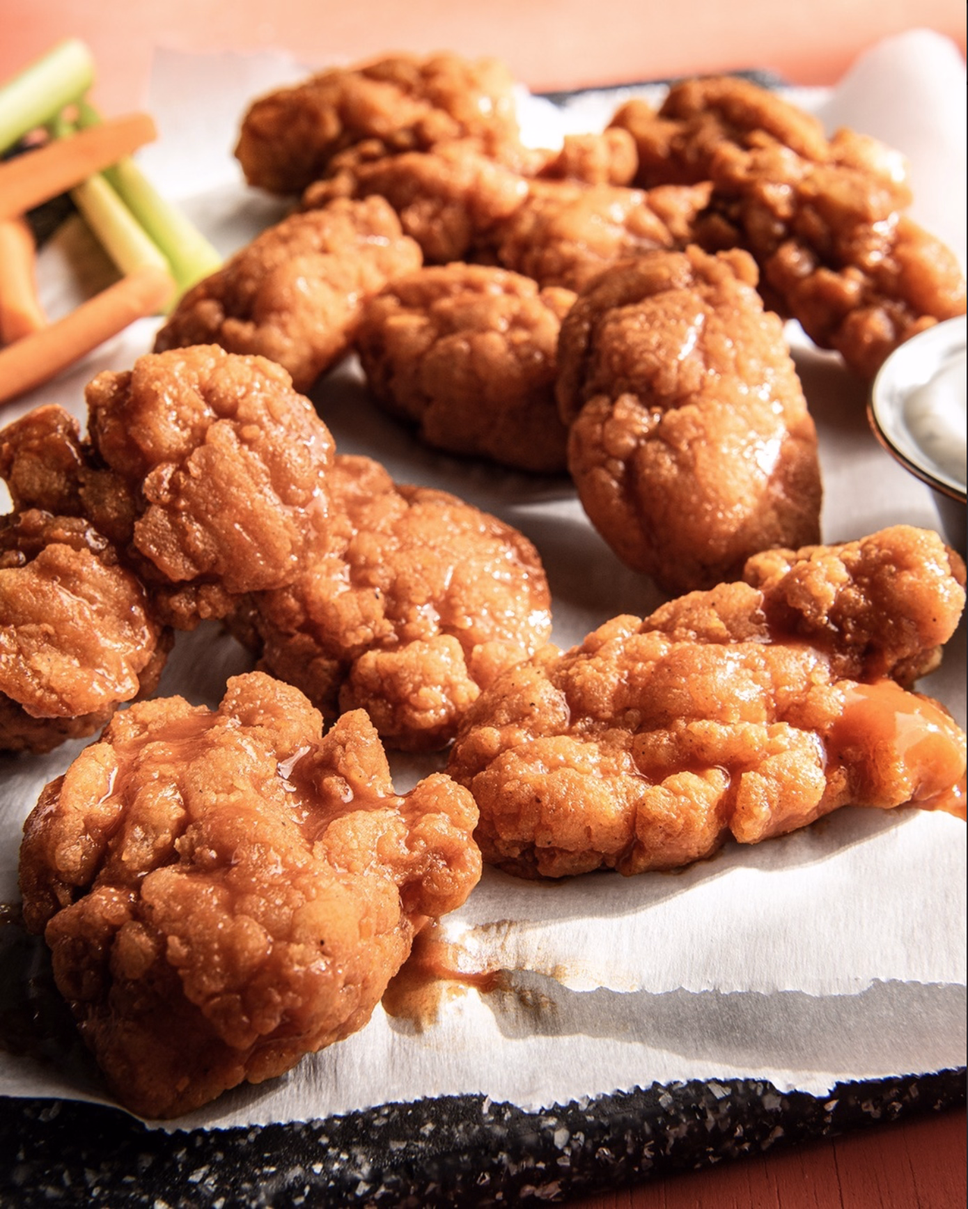 Platter of buffalo-style boneless wings served with cool ranch dip and crunchy celery.