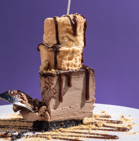 Decadent chocolate mousse cake topped with whipped cream and chocolate drizzle.