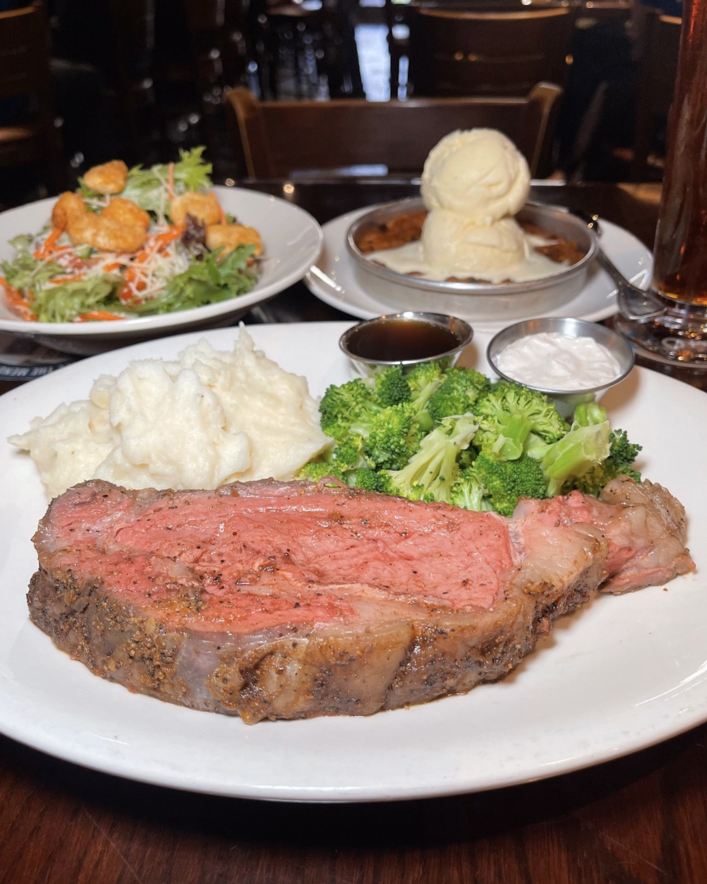 A juicy cut of prime rib paired with steamed broccoli and creamy mashed potatoes.