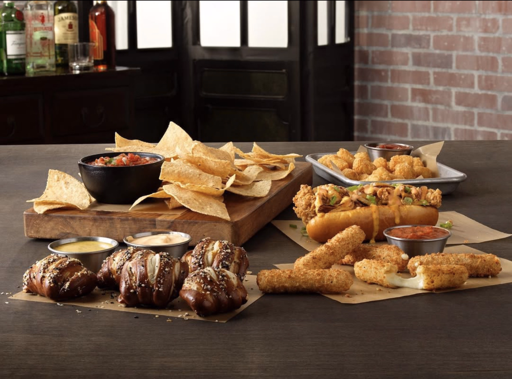 Buffalo Wild Wings happy hour appetizers with chips, salsa, mozzarella sticks, and loaded hot dogs.