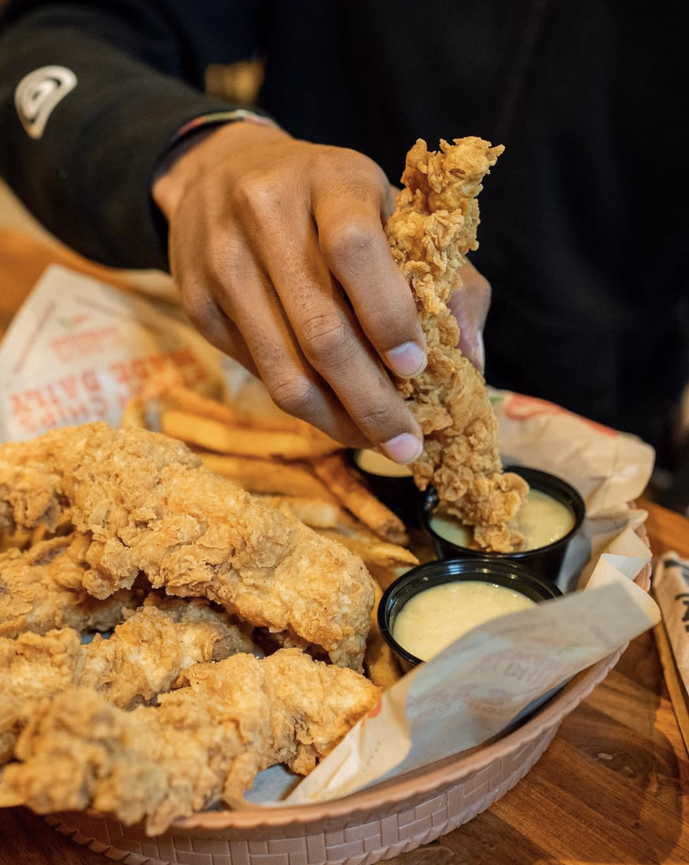 Chili’s chicken crispers with corn on the cob, fries, salsa, and crispy tortilla chips on a bright yellow surface.