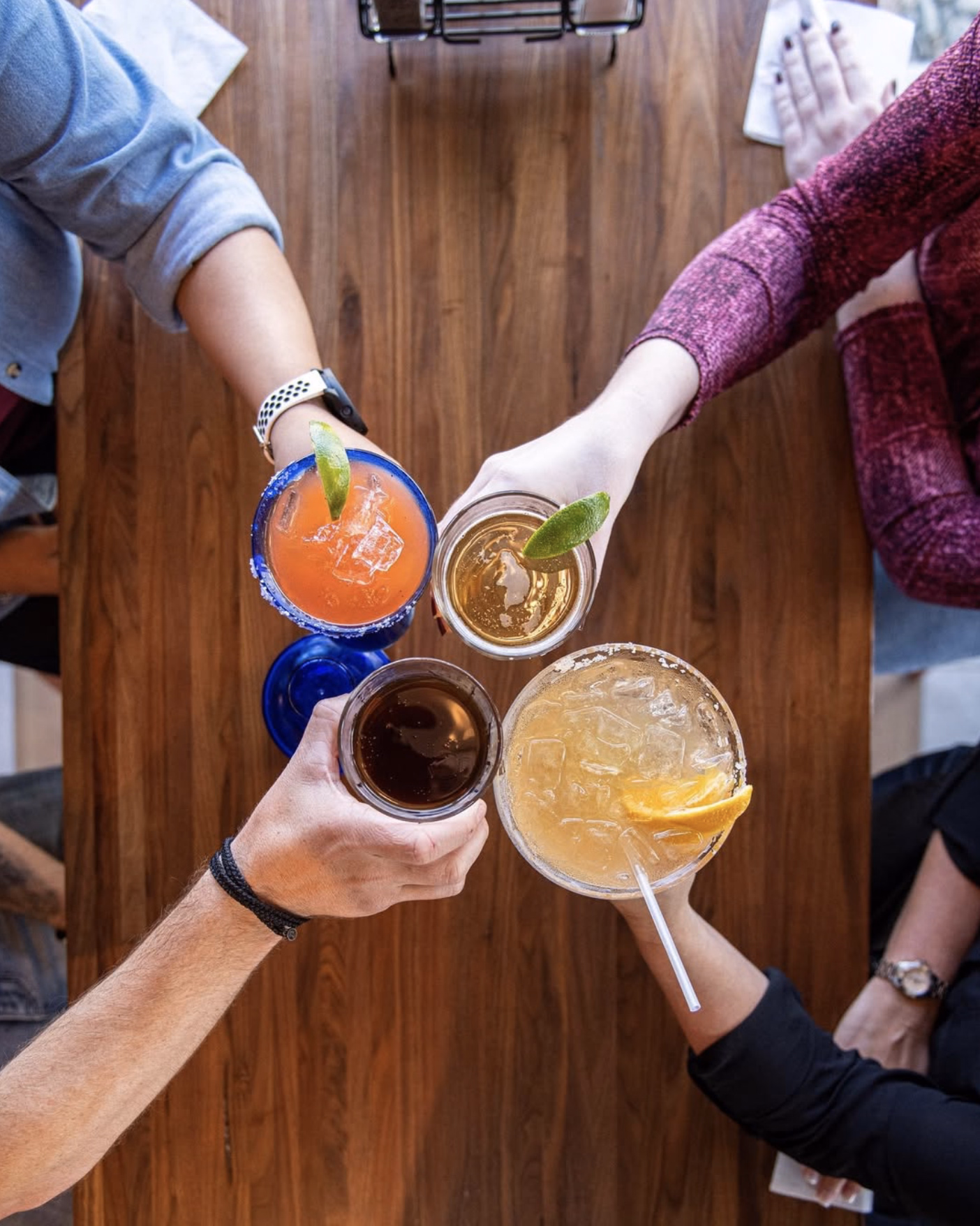 A Chili’s margarita with a salted rim and fresh lime wedge, held by a server.