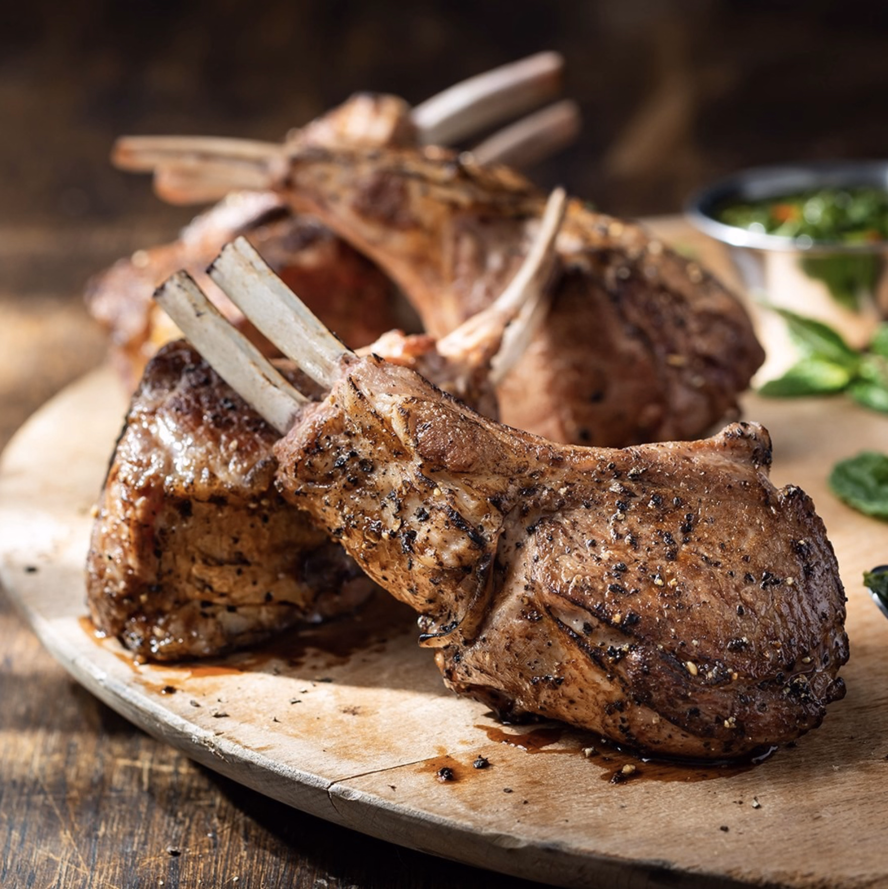 Brazilian-style lamb chops seasoned and flame-grilled, displayed on a rustic wooden board.