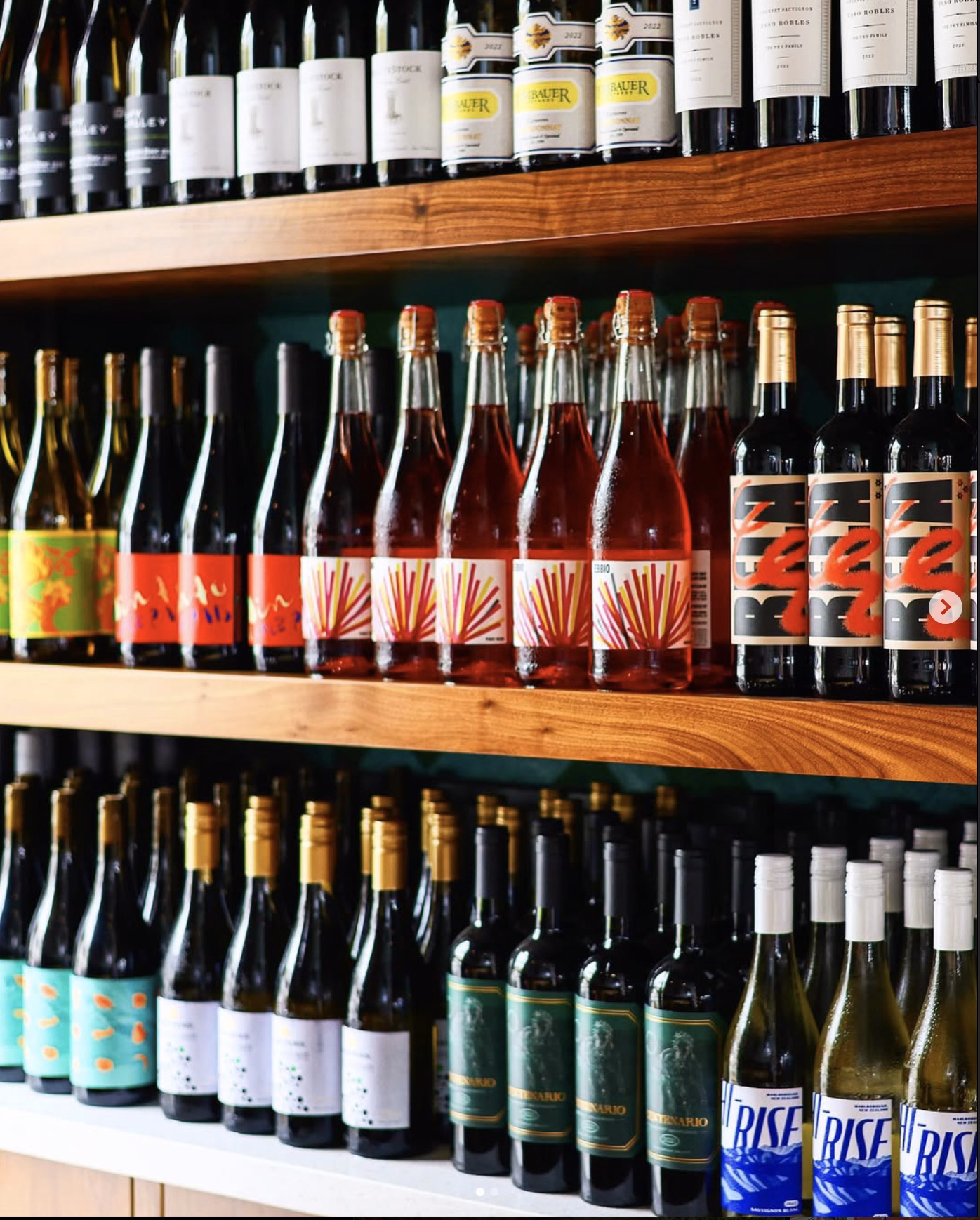 A curated display of assorted wines featuring bold label designs and vibrant bottle colors.