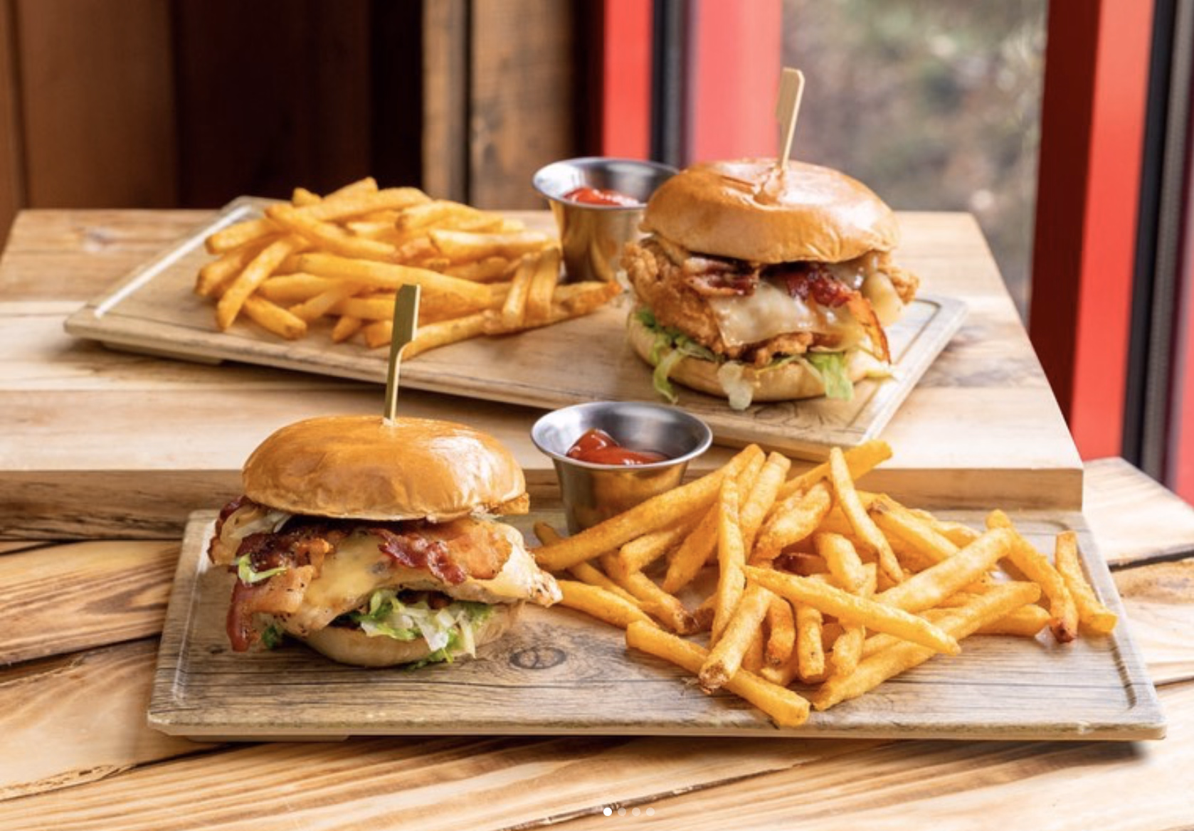 Crispy chicken sandwich plates with golden fries and sauce.