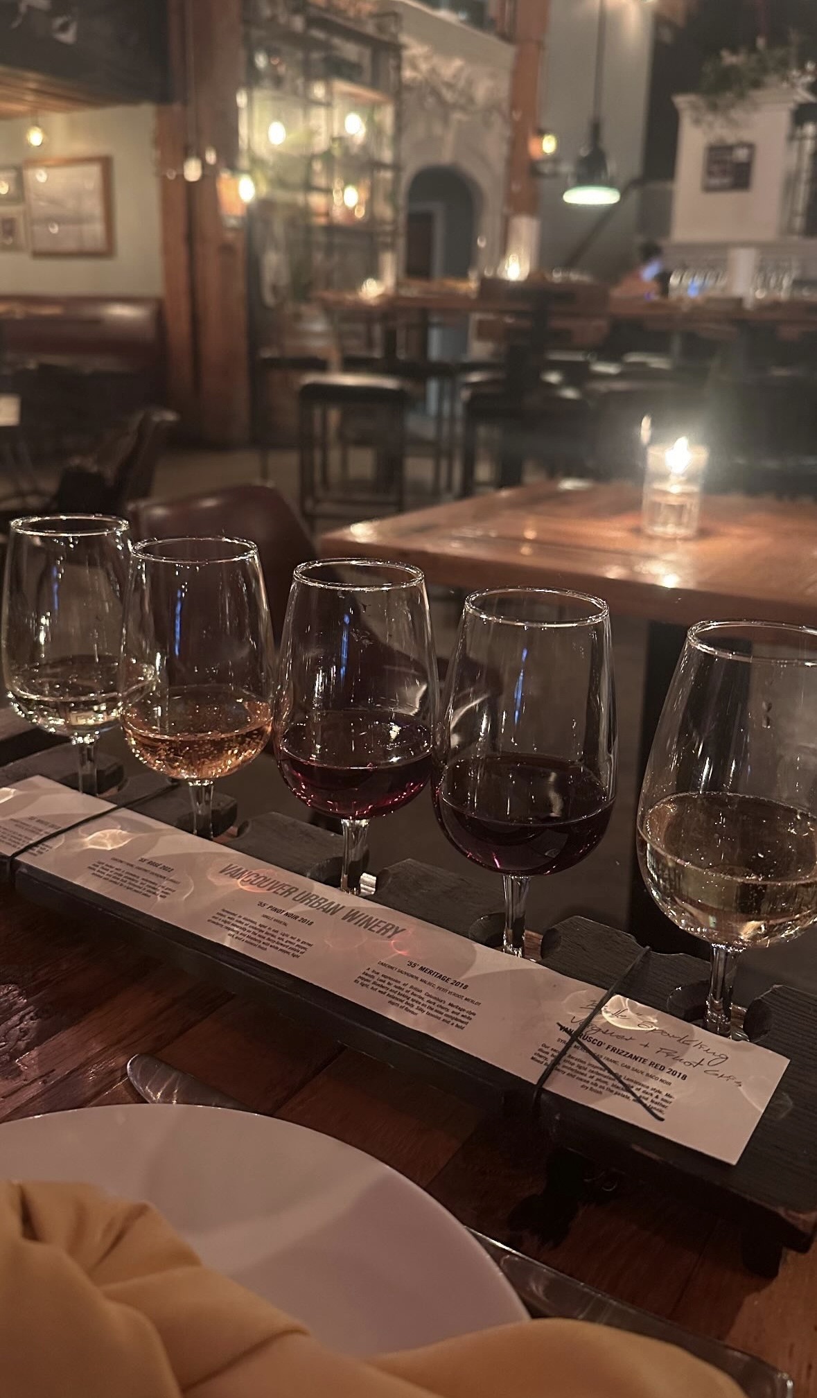 Five wine glasses on a tasting board at a winery.